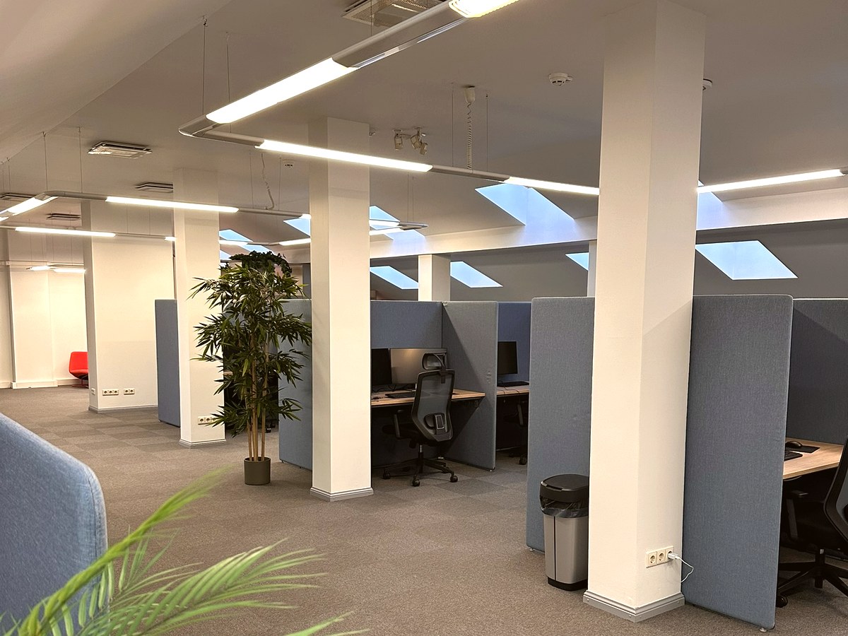 Spacious office floor with plants and skylights